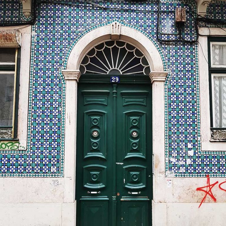 Green door on a blue and green tiled building, Lisbon Portugal