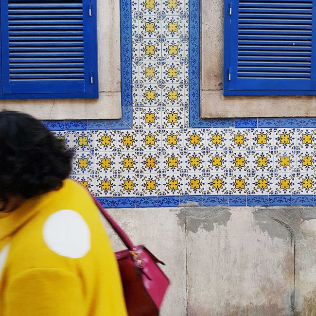 Yellow, blue and white tiles on the side of a building in Lisbon, Portugal