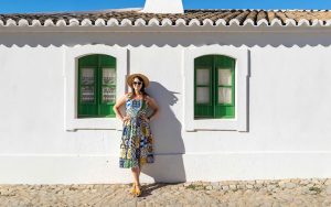 Daniela wearing a tile dress standing in front of a white Portuguese building in the Algarve