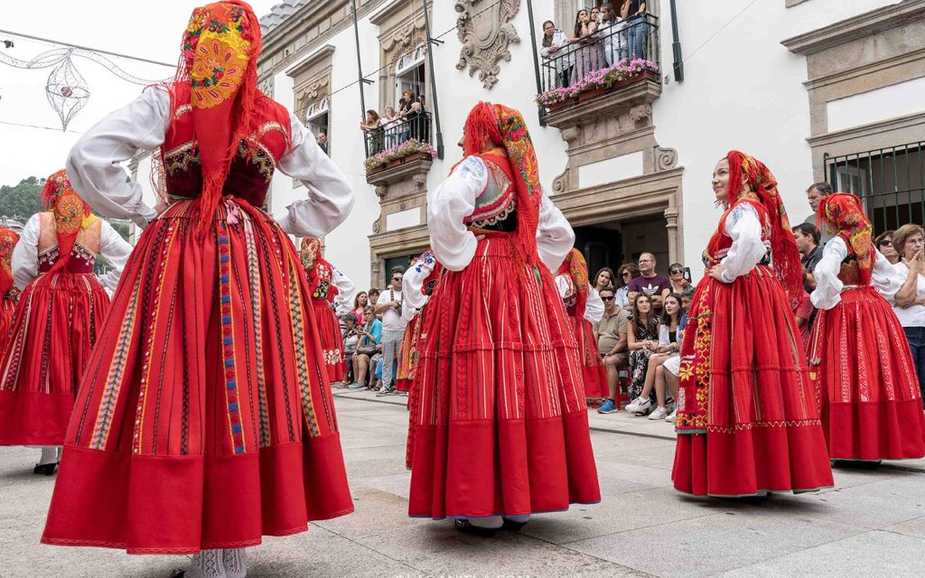 Traditional red lavradeira costumes at the Romaria de Nossa Senhora d'Agonia in Viana do Castelo during the Mordomia Parade or Desfile de Mordomia