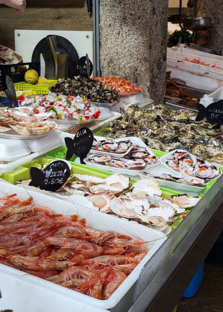 Seafood including prawns, scallops, oysters and goose barnacles at the famous Abastos Markets in Santiago de Compostela, Galicia, Spain