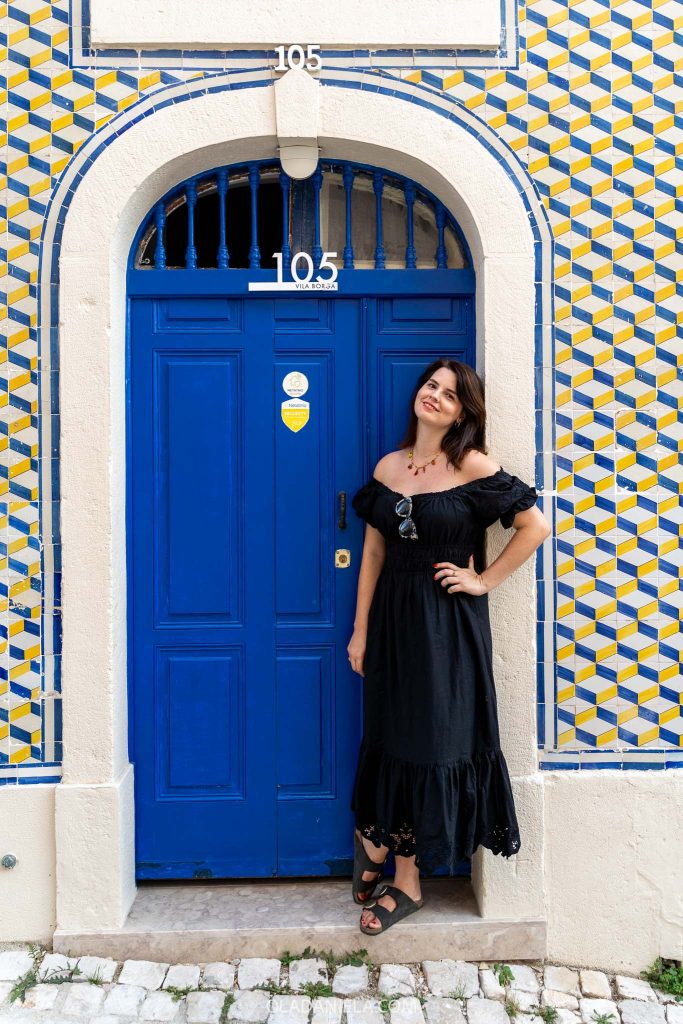 Daniela standing in front of a blue-and-yellow tiled wall