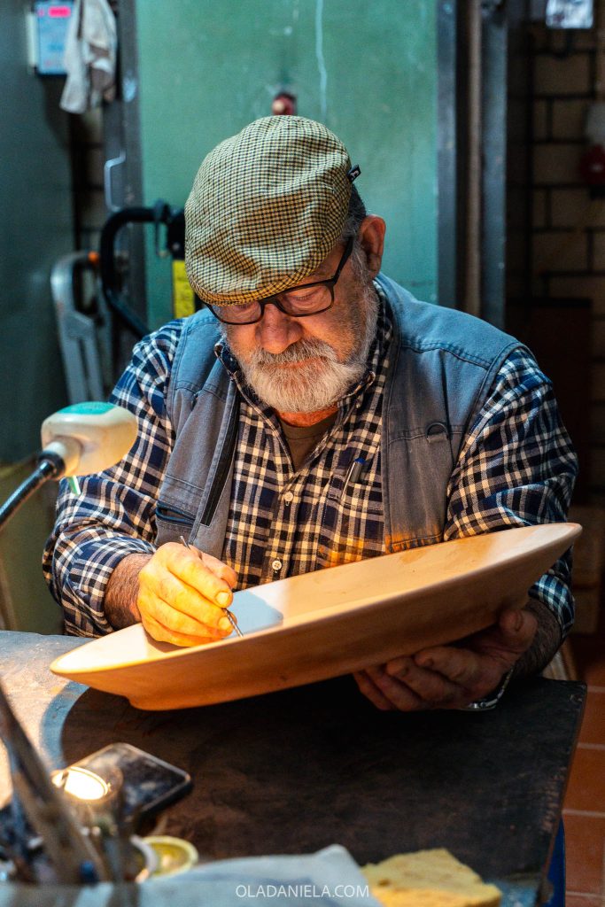 Master Xico Tarefa painting a terracotta plate at Olaria XT pottery workshop in Redondo, Alentejo